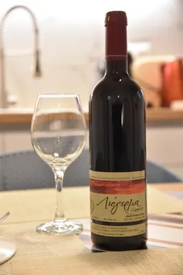 a bottle of wine next to a glass on a table at Ηλιόλουστο in Athens