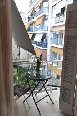 a table and chairs on a balcony with a building at Ηλιόλουστο in Athens