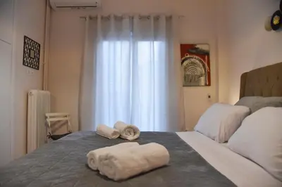 a bed with two towels on it with a window at Ηλιόλουστο in Athens