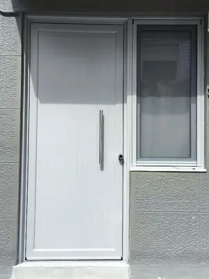 a white door with a window on a building at Microhome in Philopappos Hill in Athens