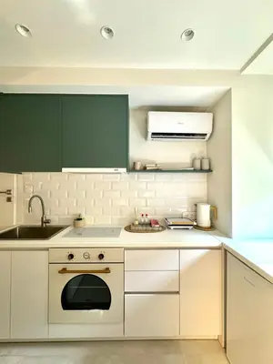 a kitchen with white cabinets and a sink at Microhome in Philopappos Hill in Athens