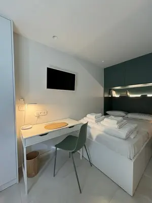 a bedroom with a bed with a desk and a tv at Microhome in Philopappos Hill in Athens