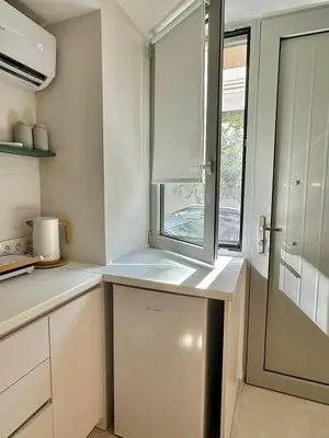 a kitchen with a window and a white refrigerator at Microhome in Philopappos Hill in Athens