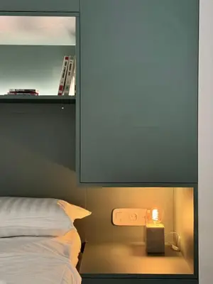 a bedroom with a bed and a nightstand with a candle at Microhome in Philopappos Hill in Athens