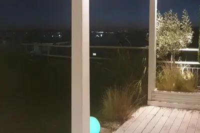 a view of a balcony at night from a window at Spacious top flat with panoramic rooftop in Athens
