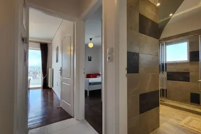 a bathroom with a walk in shower next to a door at Spacious top flat with panoramic rooftop in Athens