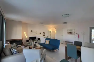 a living room with a couch and a blue chair at Spacious top flat with panoramic rooftop in Athens