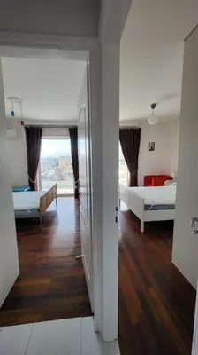 a room with two beds and a room with a hallway at Spacious top flat with panoramic rooftop in Athens