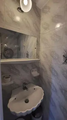 a bathroom with a white sink and a mirror at Spacious top flat with panoramic rooftop in Athens