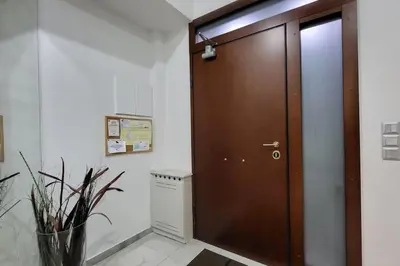 a brown door in a room with a vase at Spacious top flat with panoramic rooftop in Athens