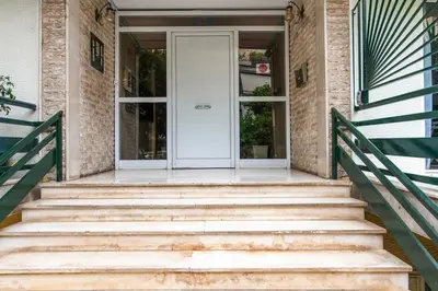 a set of stairs leading to a white door at Ella's Cozy escape with balcony! in Athens