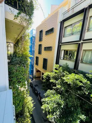 an alley between two buildings with bushes at Arame Luxury Apartments in Athens