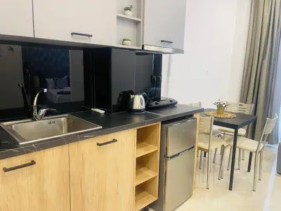 a kitchen with a sink and a table with chairs at Arame Luxury Apartments in Athens