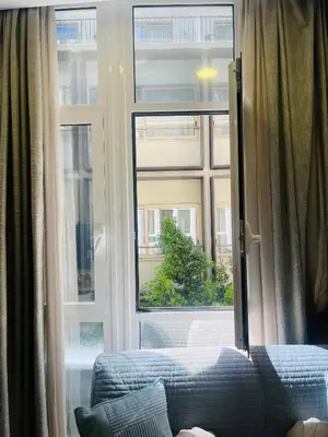 a bedroom with a large window and a couch in front at Arame Luxury Apartments in Athens
