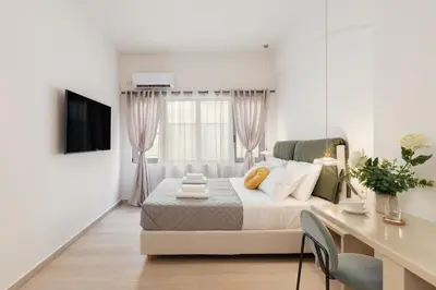 a white bedroom with a bed and a desk at M18 Studios Monastiraki Gems in Athens