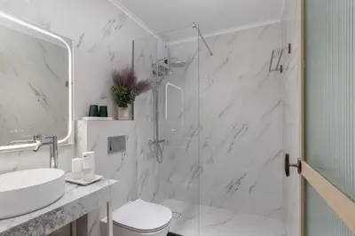a white bathroom with a shower and a sink at M18 Studios Monastiraki Gems in Athens