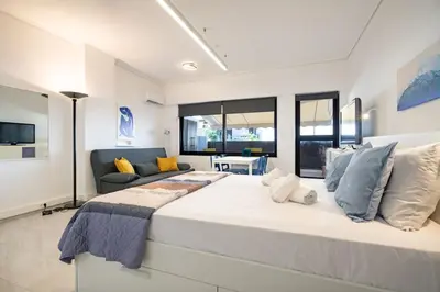 a large white bedroom with a large bed and a couch at Stylish studio for 2 in Abelokipi by MPS in Athens