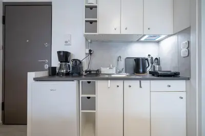 a kitchen with white cabinets and a sink at Stylish studio for 2 in Abelokipi by MPS in Athens