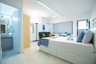 a bedroom with a large bed and a bathroom at Stylish studio for 2 in Abelokipi by MPS in Athens