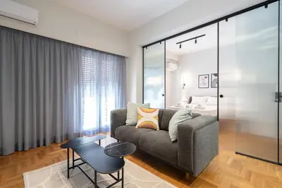 a living room with a couch and a bed at LIV - Peaceful Pagrati Getaway in Athens