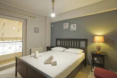 a bedroom with a bed with white sheets and a window at Seaside Spacious 2 BR, 2BA, Sea view Apt in Piraeus