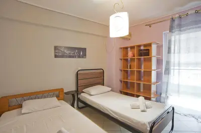 a room with two beds and a book shelf at Seaside Spacious 2 BR, 2BA, Sea view Apt in Piraeus
