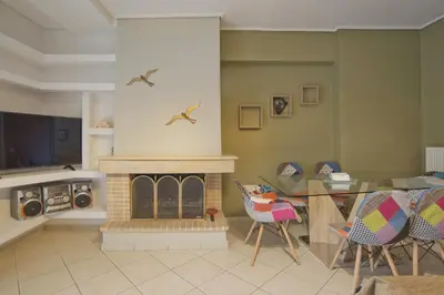 a living room with a fireplace and a table and chairs at Seaside Spacious 2 BR, 2BA, Sea view Apt in Piraeus