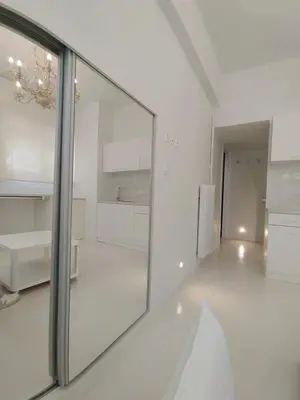 a large white kitchen with a large mirror at AMG Stylish Small Apartment in Pagkrati Close to Metro in Athens
