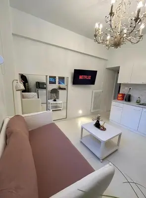 a living room with a couch and a table at AMG Stylish Small Apartment in Pagkrati Close to Metro in Athens