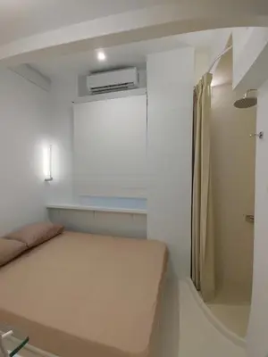 a small bedroom with a bed and a refrigerator at AMG Stylish Small Apartment in Pagkrati Close to Metro in Athens