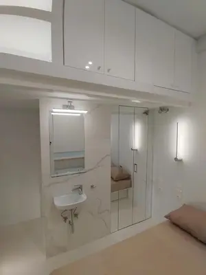 a white bathroom with a sink and a shower at AMG Stylish Small Apartment in Pagkrati Close to Metro in Athens