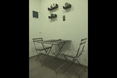 a table and chairs in a room with a wall at Athens Dream in Athens