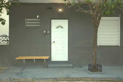 a house with a white door and a wooden bench at Athens Dream in Athens