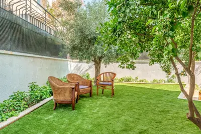 three chairs and a table on a lawn at YourHostess in Athens