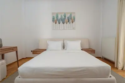 a bedroom with a large white bed with two pillows at YourHostess in Athens