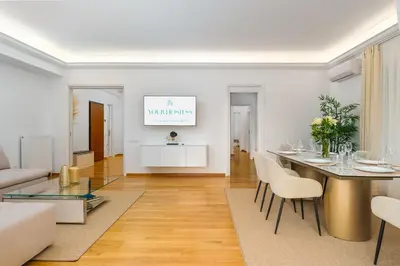 a white living room with a table and chairs at YourHostess in Athens