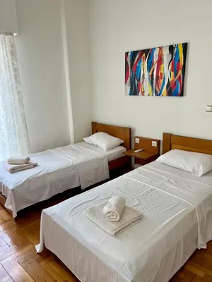 two beds in a hotel room with towels on them at TOMS apartment Acropolis district in Athens