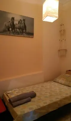 a bedroom with a bed and a painting of horses on the wall at Vintage house by the sea in althea in Aghia Marina