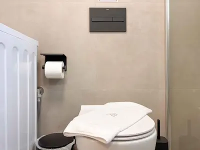 a bathroom with a toilet with a towel on it at Cozy Flat near Glyfada Center in Athens