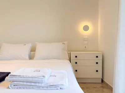 a bedroom with a white bed with towels on it at Cozy Flat near Glyfada Center in Athens