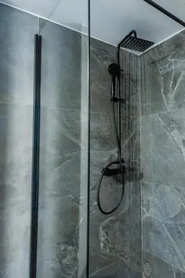 a shower with a glass door in a bathroom at CHARĀ Apartment in Plaka, Under The Acropolis in Athens