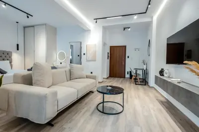 a living room with a white couch and a table at CHARĀ Apartment in Plaka, Under The Acropolis in Athens