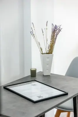 a tablet sitting on a table with a vase at CHARĀ Apartment in Plaka, Under The Acropolis in Athens