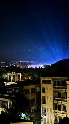 a view of a city at night at CHARĀ Apartment in Plaka, Under The Acropolis in Athens