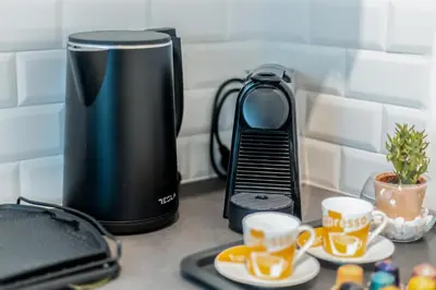 a coffee maker and two cups on a counter at CHARĀ Apartment in Plaka, Under The Acropolis in Athens