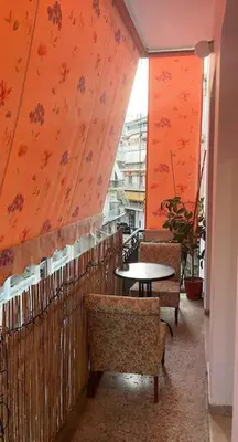 a table and chairs in a room with orange walls at Dimis Apartment in Athens