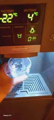 a person holding a bowl in front of a machine at Dimis Apartment in Athens