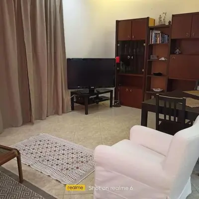 a living room with a white couch and a television at Dimis Apartment in Athens