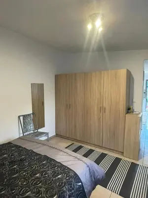 a bedroom with a large bed and wooden cabinets at Simple Stay Vari's House in Vari