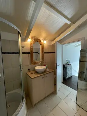 a bathroom with a sink and a shower and a mirror at Simple Stay Vari's House in Vari
